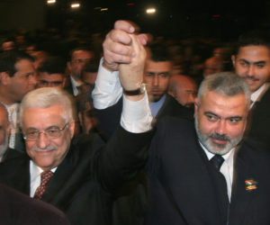 In this file photo taken on March 17, 2007, Palestinian Authority President Mahmoud Abbas, left, and Prime Minister Ismail Haniyeh from Hamas, right, raise their linked arms as they move through the crowd at a special session of parliament in Gaza City.