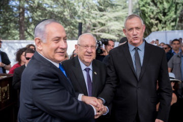 Blue and White leader MK Benny Gantz, right, shakes hands with President Reuven Rivlin, center, and Prime Minister Benjamin Netanyahu at a memorial ceremony for the late President Shimon Peres, at the Mount Herzl cemetery in Jerusalem, on September 19, 2019.