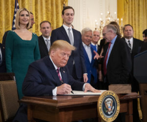 President Donald Trump signs an executive order combatting anti-Semitism in the U. S. during a Hanukkah reception in the East Room of the White House Wednesday, Dec. 11, 2019, in Washington.