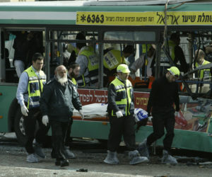 Paramedics and police carry away one of the victims killed in a suicide bombing on a Jerusalem bus, February 22, 2004.