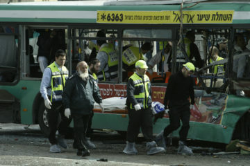 Paramedics and police carry away one of the victims killed in a suicide bombing on a Jerusalem bus, February 22, 2004.