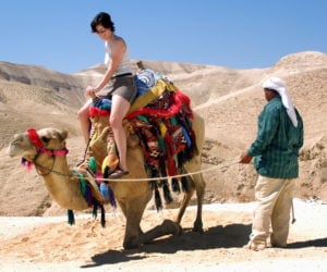 A tourist rides a camel in