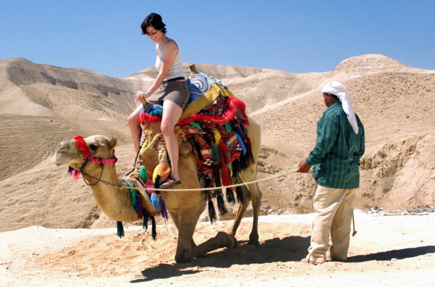 A tourist rides a camel in