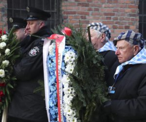Survivors carry a wreath at the Auschwitz Nazi death camp in Oswiecim, Poland, Monday, Jan. 27, 2020.