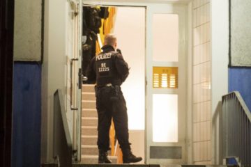 Police forces are standing in the hallway of an apartment building in Marzahn-Hellersdorf, Germany, Tuesday, Jan.14, 2020.