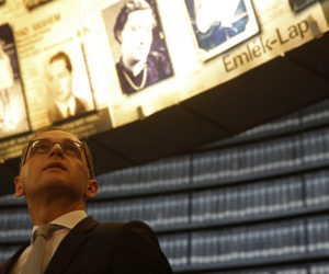 German Foreign Minister Heiko Maas looks at pictures of Jews killed during the Holocaust, in the Hall of Names at Yad Vashem Holocaust Museum in Jerusalem, March 25, 2018.