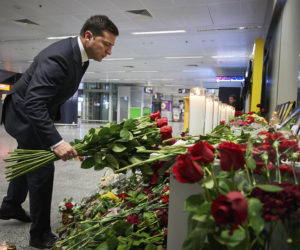Ukrainian President Volodymyr Zelenskiy lays flowers at Borispil International Airport outside Kyiv, Ukraine, where a memorial was set up in the aftermath of the crash of a Ukrainian airliner in Iran.