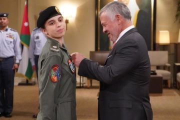 King Abdullah II presents Princess Salma bint Abdullah with her wings after she completed preliminary pilot training.