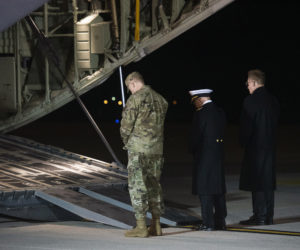 Military personnel pause in silence at Air Force cargo plane carrying the remains of those killed in a shooting at an Naval Air Station in Pensacola, Florida on December 6, 2019.