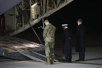 Military personnel pause in silence at Air Force cargo plane carrying the remains of those killed in a shooting at an Naval Air Station in Pensacola, Florida on December 6, 2019.
