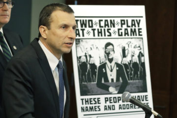Raymond Duda, FBI Special Agent in Charge in Seattle, speaks as he stands next to a poster that was mailed earlier in the year to the home of Chris Ingalls, an investigative reporter with KING-TV in Seattle, Wednesday, Feb. 26, 2020, during a news conference in Seattle.