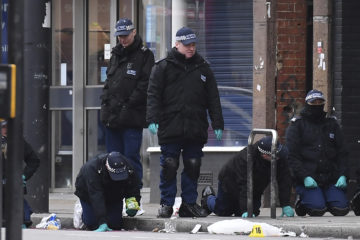 Police officers work at the scene of Sunday's terror stabbing attack in the Streatham area of south London on Monday, Feb. 3, 2020.