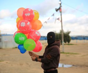 Palestinian prepares a a booby-trapped "bouquet" of balloons to be flown toward Israel, near the Israel-Gaza border east of Al-Bureij refugee camp in the central Gaza Strip on February 10, 2020.