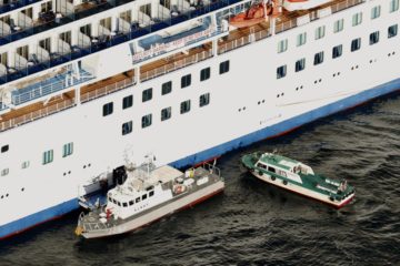 Japan Coast Guard's patrol boat, left, is brought alongside the cruise ship Diamond Princess to take passengers tested positive for coronavirus to hospitals off Yokohama, south of Tokyo, Wednesday, Feb. 5, 2020.