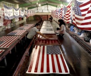 In this Saturday, Feb. 8, 2020 photo, workers print U.S. and Israeli flags at the Diba Parcham Khomein factory in Heshmatieh village, a suburb of Khomein city, in central Iran.