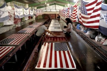 In this Saturday, Feb. 8, 2020 photo, workers print U.S. and Israeli flags at the Diba Parcham Khomein factory in Heshmatieh village, a suburb of Khomein city, in central Iran.