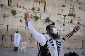 Jewish men pray at the Western Wall
