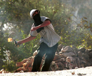 A Palestinian youth hurls a Molotov cocktail