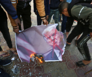 Palestinians burn images of US President Donald Trump during a demonstration in protest of a US-brokered peace proposal, in Rafah in the southern Gaza Strip, on March 3, 2020. (Abed Rahim Khatib/Flash90)