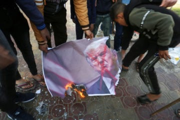 Palestinians burn images of US President Donald Trump during a demonstration in protest of a US-brokered peace proposal, in Rafah in the southern Gaza Strip, on March 3, 2020. (Abed Rahim Khatib/Flash90)