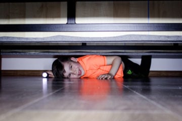 boy hiding under bed