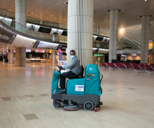 An airport staff cleaner disinfects the empty arrival hall at Ben Gurion Airport on June 12, 2020. (Flash90/Olivier Fitoussi)
