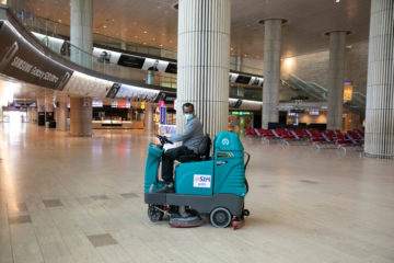 An airport staff cleaner disinfects the empty arrival hall at Ben Gurion Airport on June 12, 2020. (Flash90/Olivier Fitoussi)