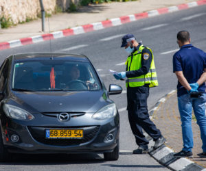 An Israeli police officer stops a driver at a roadblock in Jerusalem, on April 29, 2020. (Flash90/Olivier Fitoussi)