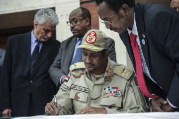 Gen. Mohammed Hamdan Dagalo signs a power sharing document with Sudan's pro-democracy movement and the ruling military council in Khartoum, Sudan on July 17, 2019. (AP Photo/Mahmoud Hjaj)