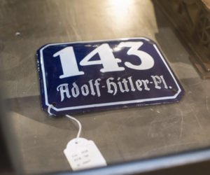 In this Wednesday, Nov. 20, 2019, photo, a street sign for '143 Adolf Hitler Place' is displayed for an auction at the 'Hermann Historica' auction house in Grasbrunn near Munich, Germany. (AP Photo/Matthias Balk)