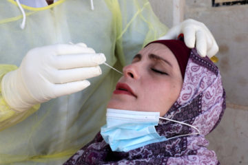 A Palestinian health worker tests Palestinians for coronavirus disease (COVID-19) near Hebron on July 29, 2020. (Flash90/Wisam Hashlamoun)