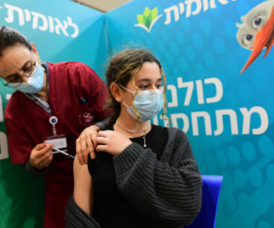 An Israeli student receives a Covid-19 vaccine injection, at Leumit Covid-19 vaccination center in Tel Aviv, on January 23, 2021. (Flash90/Avshalom Sassoni)