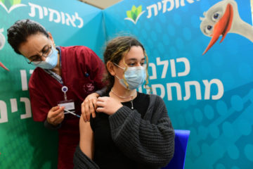 An Israeli student receives a Covid-19 vaccine injection, at Leumit Covid-19 vaccination center in Tel Aviv, on January 23, 2021. (Flash90/Avshalom Sassoni)