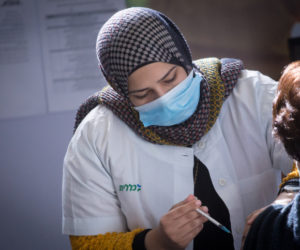 A nurse administers a coronavirus vaccine in Petach Tikva, Israel, on January 27, 2021. (Flash90/Miriam Alster)