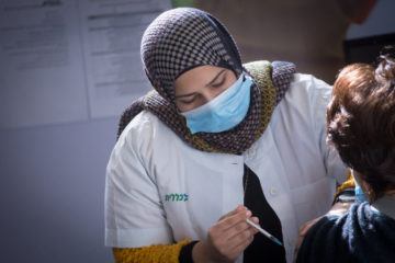 A nurse administers a coronavirus vaccine in Petach Tikva, Israel, on January 27, 2021. (Flash90/Miriam Alster)