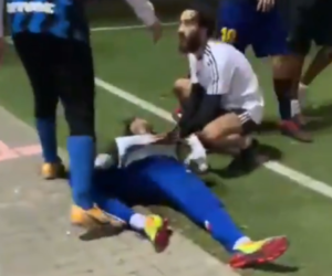 An Israeli aids a teammate who was knocked unconscious by an illegal migrant during a confrontation on a south Tel Aviv soccer field. (Twitter/Doron Avrahami/Screenshot)