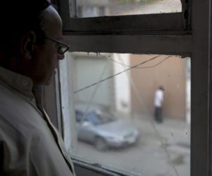 Zebulon Simentov, the last known Jew living in Afghanistan, looks out onto the street below from the window in his Kabul home. (Credit: AP Photo/David Goldman)