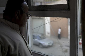 Zebulon Simentov, the last known Jew living in Afghanistan, looks out onto the street below from the window in his Kabul home. (Credit: AP Photo/David Goldman)
