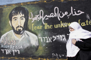 Palestinians walk past a mural painted by a Hamas artist of captured Israeli soldier Gilad Shalit in the northern Gaza Strip.