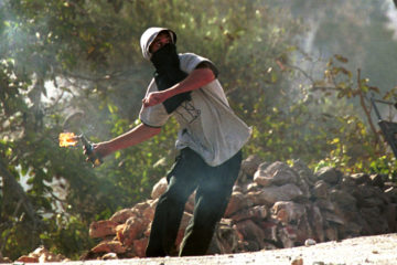 A Palestinian youth hurls a molotov cocktail