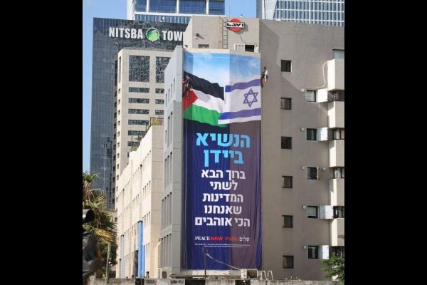 Peace Now hangs sign with Palestinian flag in Tel Aviv ahead of Biden visit