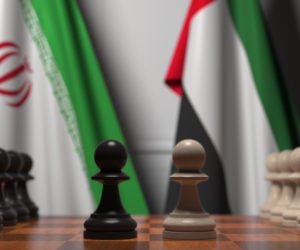 Flags,Of,Iran,And,Uae,Behind,Pawns,On,The,Chessboard.