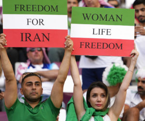 Iranian soccer fans hold up signs reading Woman Life Freedom and Freedom For Iran, at the World Cup in Doha, Qatar, Monday, Nov. 21, 2022. (AP Photo/Alessandra Tarantino)