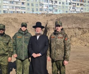 Rabbi Pinchas Salzman stands with soldiers in a Jewish mass grave in Transnistria credit Moldova Jewish community