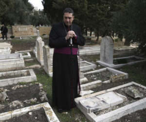 Hosam Naoum, an Anglican bishop, pauses where vandals desecrated more than 30 graves at a historic Protestant Cemetery on Jerusalem's Mount Zion in Jerusalem, Wednesday, Jan. 4. (AP Photo/ Mahmoud Illean)