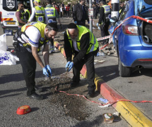 Members of Zaka Rescue and Recovery team work at the site of a car-ramming attack that killed three Israelis at a bus stop in Ramot, Jerusalem, Friday, Feb. 10, 2023. (AP Photo/Mahmoud Illean)