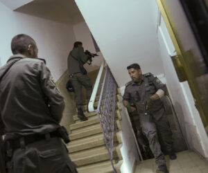 Israeli police officers run upstairs as they search for a Palestinian terrorist in a shooting attack in Tel Aviv, which wounded three people Thursday, March 9, 2023. (AP Photo/Oded Balilty)