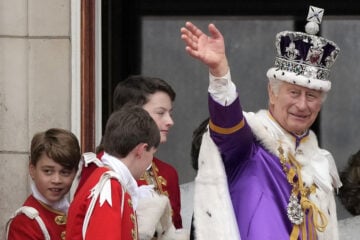 Britain's King Charles III waves from the balcony of Buckingham Palace as Prince George, left, watches after the coronation ceremony in London, Saturday, May 6, 2023. (AP Photo/Frank Augstein)