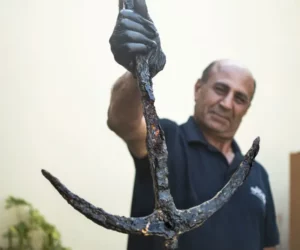 IAA Archaeologist Marwan Masr'wah with the returned anchor (photo credit: YULI SCHWARTZ/IAA)
