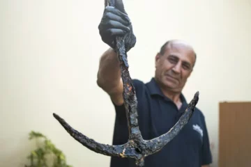 IAA Archaeologist Marwan Masr'wah with the returned anchor (photo credit: YULI SCHWARTZ/IAA)